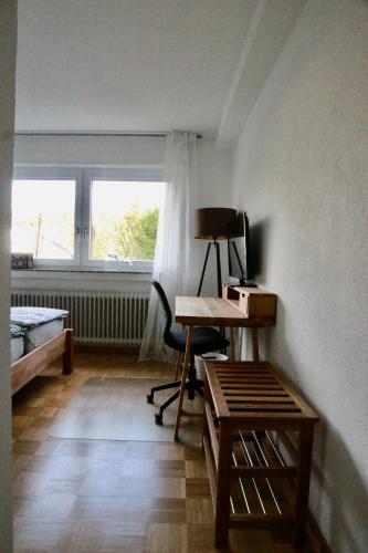 a room with a desk and a chair and a window at Ferienappartement Albschätzle in Bronnen