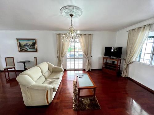 a living room with a white couch and a chandelier at Classic Tranquil Madeiran 4-Bedroom Villa Funchal in Funchal