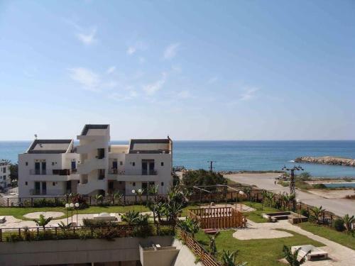 a large white building with the ocean in the background at Chalet In Solemar, 2br, Elec247, Parking, Wifi in Al Kaslīk