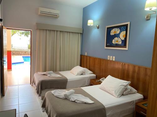 two beds in a hotel room with blue walls at Terwindt Hotel in Encarnación