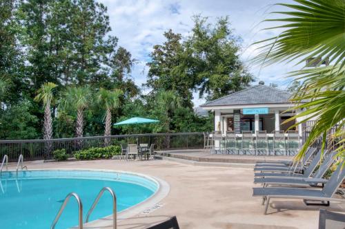 un complejo con piscina con sillas y cenador en Hampton Inn & Suites Wilmington/Wrightsville Beach, en Wilmington