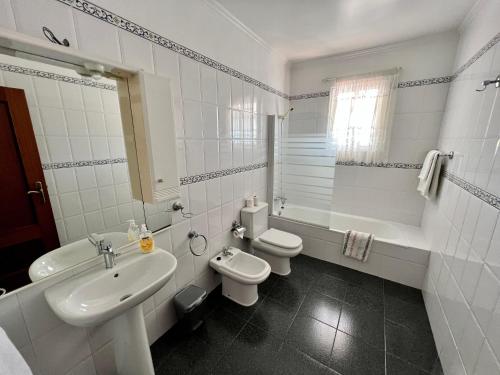 a white bathroom with a sink and a toilet at Classic Tranquil Madeiran 4-Bedroom Villa Funchal in Funchal
