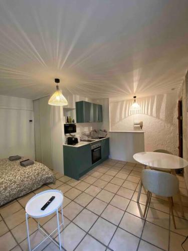 Cette chambre comprend un lit, une table et une cuisine. dans l'établissement Studio climatisé neuf centre-ville, à Nîmes