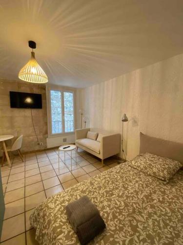 une chambre avec un lit et un canapé dans une pièce dans l'établissement Studio climatisé neuf centre-ville, à Nîmes