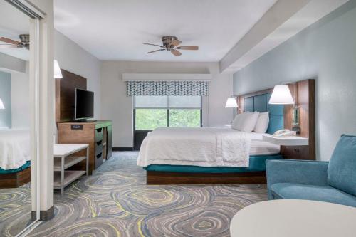a hotel room with a bed and a couch at Hampton Inn & Suites Wilmington/Wrightsville Beach in Wilmington