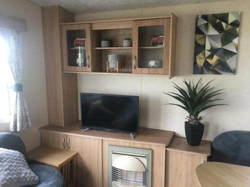 a living room with a tv on top of a fireplace at 2 Bedroom 6 berth Caravan Towyn Rhyl in Rhyl