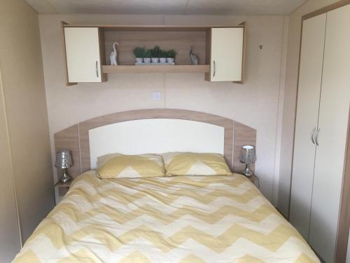 a bedroom with a bed in a small room at Towyn six berth en suite caravan in Rhyl