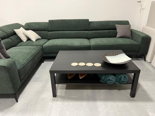 a living room with a green couch and a coffee table at Pri jazere - Golf rezort in Hrubá Borša