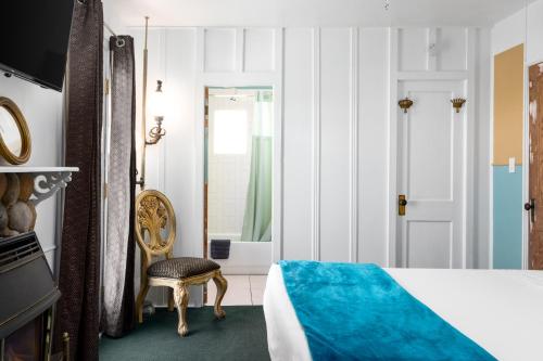 a bedroom with a bed and a chair and a door at The Motor Lodge in Prescott