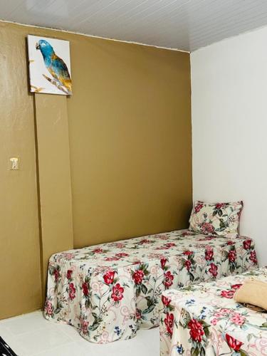 a bedroom with a bed with a floral bedspread at Hostel das Flores in Belém