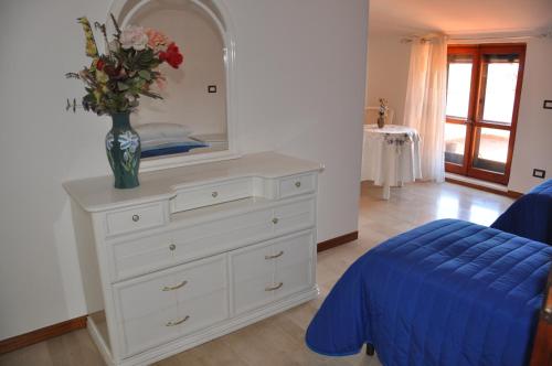 um quarto com uma cómoda com um vaso de flores em B&B La Palombara em Giuliano di Roma