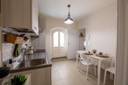 uma cozinha com um lavatório e uma mesa com cadeiras em A casa di Giuly em Florença