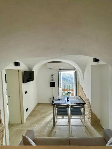 a living room with a table and a window at Greta’s suite & private spa in Perinaldo