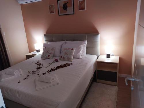 a bedroom with a white bed with flowers on it at Pine apartment in the center in Trebinje