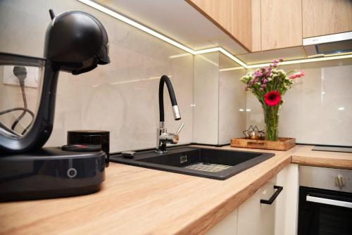 a kitchen with a sink and a vase of flowers at Pine apartment in the center in Trebinje