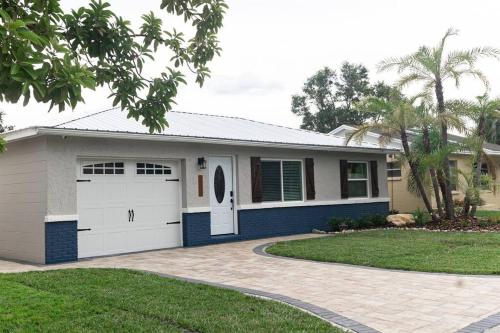 a house with a garage and a driveway at Tropical Backyard Paradise, Hot Tub, Fenced yard in Lakeland