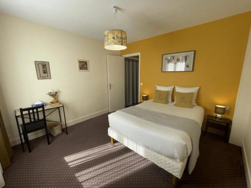 a bedroom with a bed and a table with a lamp at Hotel Le Trouville in Trouville-sur-Mer