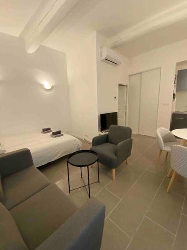 - un salon avec un lit, un canapé et des chaises dans l'établissement Studio climatisé sur courette, à Nîmes