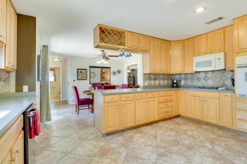 a kitchen with wooden cabinets and a dining room at 20 Mi to Austin Texas Farmhouse on 10 Acres in Manor