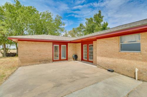 a dog is sitting in front of a brick house at 20 Mi to Austin Texas Farmhouse on 10 Acres in Manor