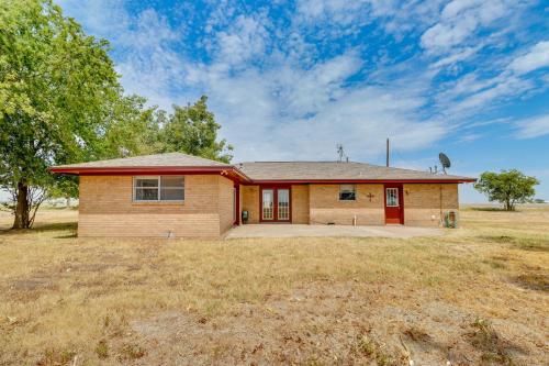 a home in a field with a house at 20 Mi to Austin Texas Farmhouse on 10 Acres in Manor
