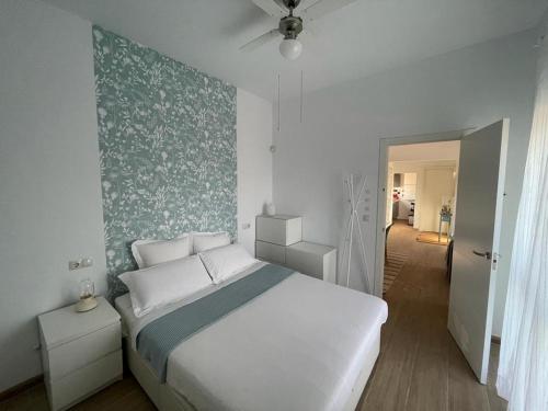 una camera con un letto bianco e una parete verde di Atico en Puerto Marina a Benalmádena