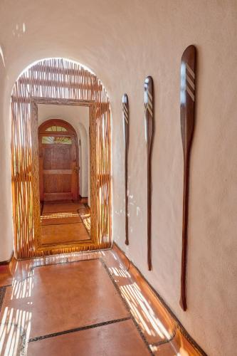 a hallway with four wooden spoons on the wall at La Villa Luz (sólo adultos) in Zihuatanejo