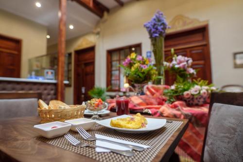 una mesa con un plato de comida encima en Santa Lucia House - Forum en Cuenca