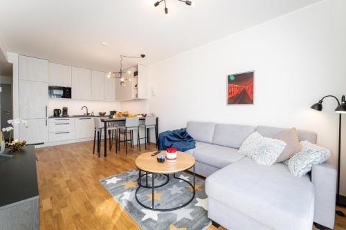 a living room with a couch and a table at Citygate Sunset balcony in Tartu