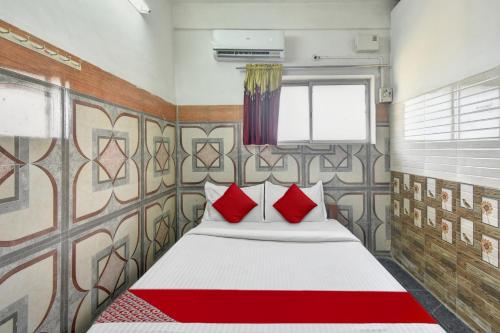 a bedroom with a large bed with red pillows at OYO Flagship R.K.R Residency in Chennai