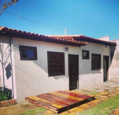 ein kleines weißes Haus mit einer Tür und einer Veranda in der Unterkunft Espaço para Festa e Pousada Alex Ávila in Diamantina