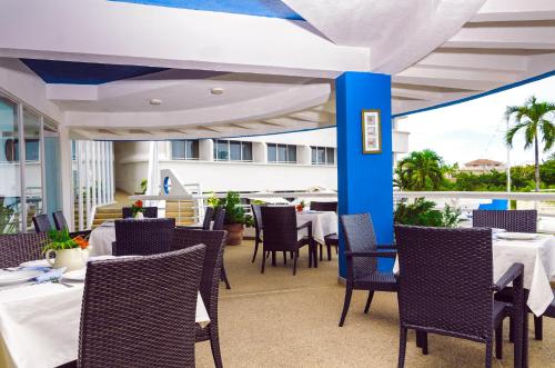 uma sala de jantar com mesas e cadeiras num pátio em Aquarius Hotel Boutique em Pampatar