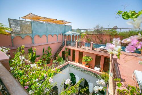 a building with a balcony with flowers on it at Riad Marélia in Marrakesh