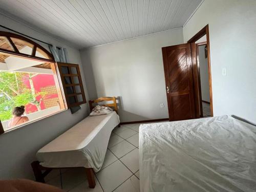 a small bedroom with a bed and a window at Praia dos Milionários in Ilhéus