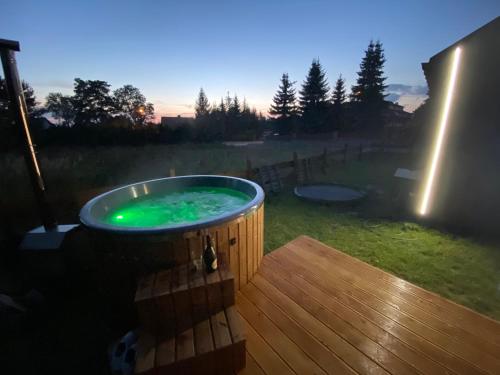a hot tub on a deck in a yard at Wypoczynkowo Domki Letniskowe in Mikołajki