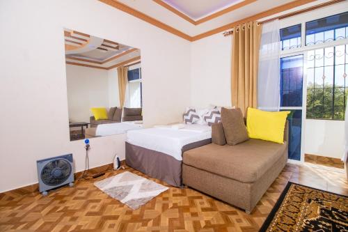 1 dormitorio con cama, silla y ventana en KITRA Cozy Homes, en Kilifi