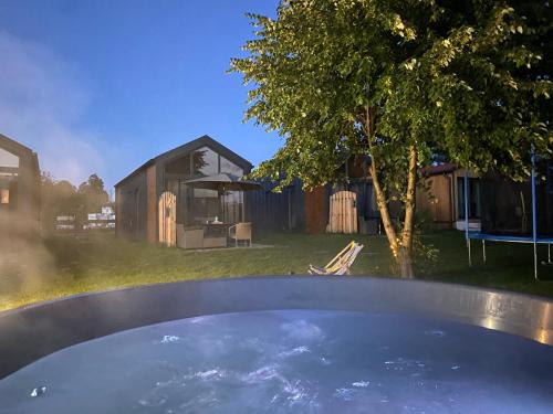 a hot tub in a yard with a house at Wypoczynkowo Domki Letniskowe in Mikołajki