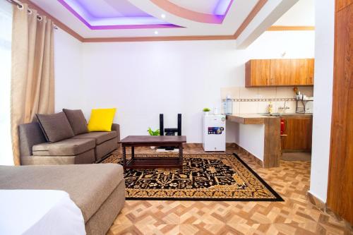 sala de estar con sofá y cocina en KITRA Cozy Homes, en Kilifi