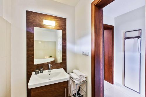 a bathroom with a sink and a mirror at Dolná 4 - apartments in direct centrum on city square in Banská Bystrica