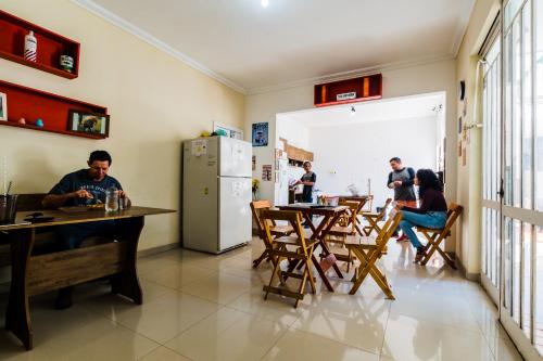 un grupo de personas sentadas en mesas en una habitación en Hostel Capivara's Lounge Bar, en Curitiba