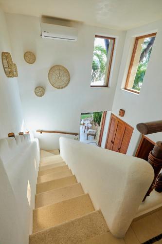 a staircase in a house with white walls at La Villa Luz (sólo adultos) in Zihuatanejo