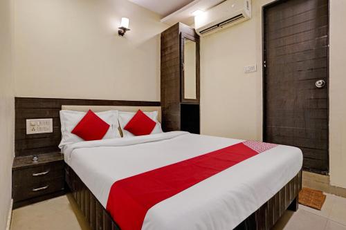 a bedroom with a large bed with red pillows at OYO Flagship Hotel Accore Inn in Mumbai