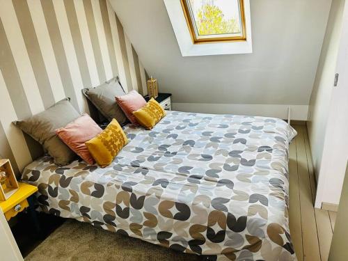 a bedroom with a bed with pillows on it at La Serjane à 300 m de la mer à Cayeux sur mer in Cayeux-sur-Mer