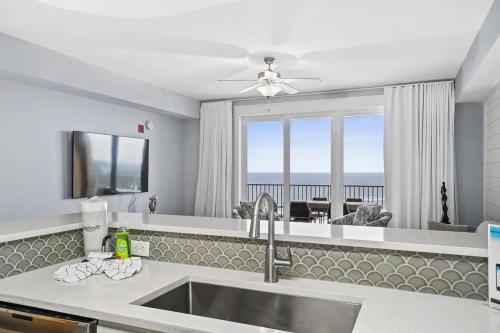 a kitchen with a sink and a view of the ocean at Calypso 3-2210 - Love Nest in Panama City Beach