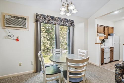 a kitchen and dining room with a table and chairs at Cedarbrook Queen Suite 106 in Killington