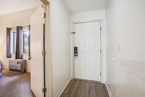 a hallway with a white door and a window at Cedarbrook Queen Suite 106 in Killington