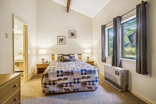 1 dormitorio con cama y ventana en Cedarbrook Queen Suite 106, en Killington