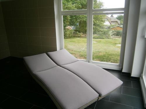 a white bench sitting in front of a window at Ferienhaus der Winde in Groß Stresow