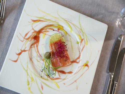 a white plate with a piece of food with sauce at Victoria - Alpine Boutique Hotel & Fine Dining in Meiringen