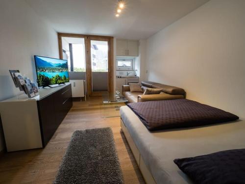 a bedroom with a bed and a flat screen tv at Tegernsee - Tolles, zentrales Appartement in Tegernsee